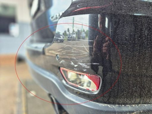 Detailaufnahme: Stoßfängerverkleidung hinten rechts in der Struktur gestaucht und verkratzt Schadengutachten nach Unfall auf Parkplatz.