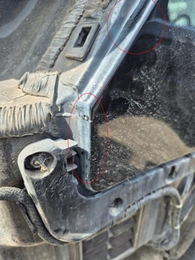 Detailaufnahme: Heckblech / Stoßfängeraufnahme deformiert Schadengutachten nach Unfall auf Parkplatz.