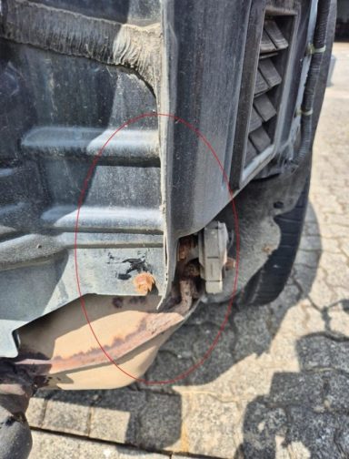 Detailaufnahme: Seitenwand innen leicht angestoßen und deformiert Schadengutachten nach Unfall auf Parkplatz.